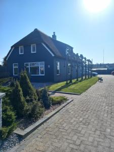 Geesbrugt' Olde kantoor的前面有一条鹅卵石街道的蓝色房子