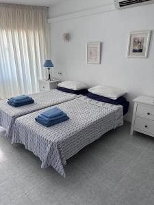 Un dormitorio con dos camas con toallas azules. en Beach Front La Cala Penthouse studio Apartment, en La Cala de Mijas 19 fotos más