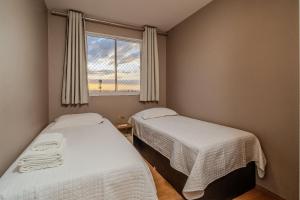 two beds in a small room with a window at Apto Completo BH ARENA MRV - Ar Condicionado e Estacionamento in Belo Horizonte +70 photos