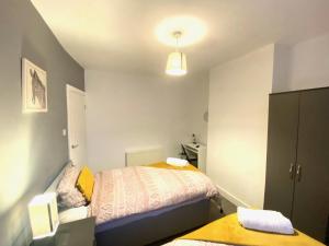 une petite chambre avec un lit et une armoire dans l'établissement Emerald Living, 4 bedrooms, sleeps 6, free parking in the heart of Swansea!, à Swansea 8 autres photos