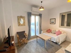 a living room with a couch and a table and a tv at Lizzy's Escape 1st floor in Kampos Paros