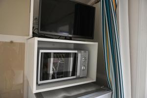 d'un four micro-ondes avec une télévision. dans l'établissement Ferienpark Süderstapel - Eiderlodge 1, à Süderstapel