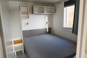 une chambre avec un lit et une fenêtre dans l'établissement Ferienpark Süderstapel - Eiderlodge 1, à Süderstapel
