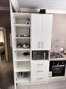 a white cabinet in a kitchen with a stove at Searle Cottage in George