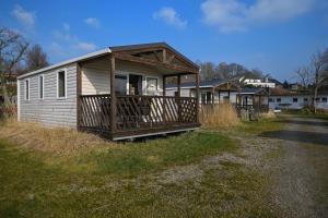 una piccola casa con un portico sul lato di una strada di Ferienpark Süderstapel - Eiderlodge 3 a Süderstapel