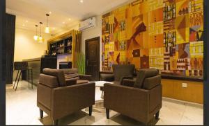 a bar with two chairs and a table in a room at Airport West Hotel in Accra