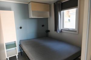 un letto in una stanza con una finestra di Ferienpark Süderstapel - Eiderlodge 3 a Süderstapel