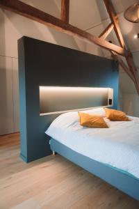 a bedroom with a bed with a blue headboard at Vakantiehuis Bie Jan Paté in Veurne