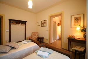 a bedroom with two beds and a chair and a mirror at CantoQuinto Bed and Breakfast in Fivizzano
