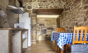 a kitchen with a table and chairs and a refrigerator at Casa do Comediante in Cerdeira