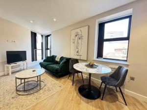 a living room with a couch and a table at Stylish City Centre Flat - Walk to Trinity & Station in Leeds