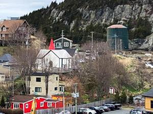 a town with houses and a hill with a barn at Unique Stay! Converted Church In Idyllic Location in St. John's