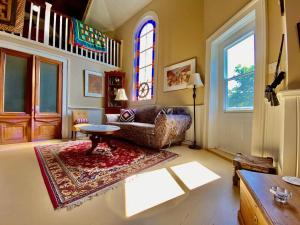 a living room with a couch and a table and a window at Unique Stay! Converted Church In Idyllic Location in St. John's