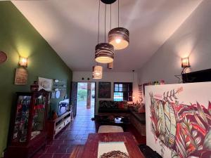 a living room with green walls and two lights at Refúgio ao lado do mar com piscina e muito charme in Ubatuba