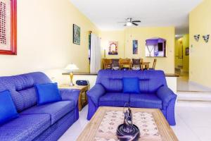 a living room with two blue couches and a table at Perfect Villa with Pool Access and Close to the Beach in Playa del Carmen