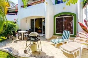 a patio with a grill and chairs and a table at Perfect Villa with Pool Access and Close to the Beach in Playa del Carmen