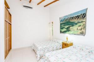 a bedroom with two beds and a painting on the wall at Perfect Villa with Pool Access and Close to the Beach in Playa del Carmen