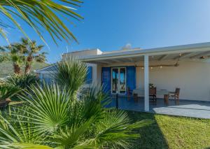 a house on the beach with palm trees at Tramonto A Nordovest in Favignana