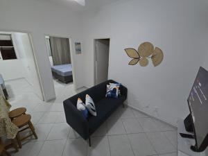 a living room with a black couch and a bedroom at Apto com linda vista mar in Santos