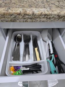 a drawer filled with utensils in a cabinet at Apto com linda vista mar in Santos +25 photos