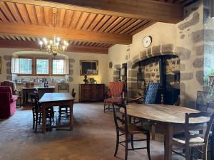 a living room with a table and a fireplace at Château du Bouy in Champétières