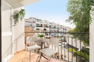 a balcony with a table and chairs and a building at Sitges Group Soul in Sitges