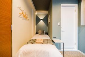 una piccola camera da letto con un letto e una finestra di UCHI Asakusabashi a Tokyo