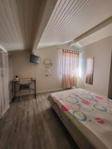 a bedroom with a large bed and a desk at Chambre ERREGUINA in Hasparren