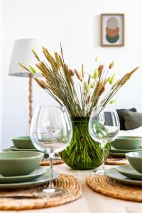 a table with two wine glasses and a vase with flowers at Chora Residence in Skopelos Town