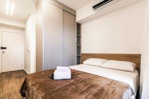 a bedroom with a large bed with white sheets at Go Vila Mariana - Studio 7 min. a pé do Metrô in Sao Paulo +35 photos