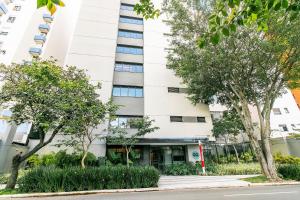 a white building with trees in front of it at Go Vila Mariana - Studio 7 min. a pé do Metrô in Sao Paulo