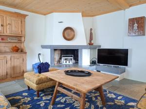 Una sala de estar con una mesa y una chimenea. en Laax Chalet by Quokka 360 - Charming Chalet with private patio, en Laax