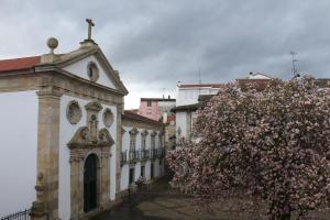 a building with a flowering tree in front of it at Casinhas Dom Afonso by Hotel Dom Afonso in Monção