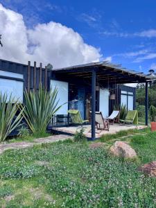 a house with a deck with chairs on a patio at Minicasas La Villa in Santa Sofía
