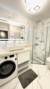 a white bathroom with a washing machine and a shower at Modern Gagarina Avenue in Dnipro