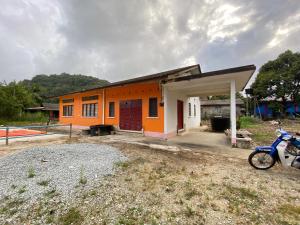 an orange building with a motorcycle parked in front of it at MY Gunung Homestay Vintage in Bachok