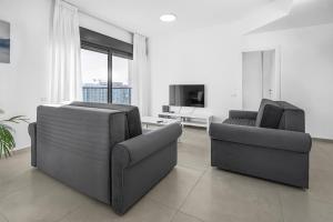 a living room with two chairs and a television at Luxury Penthouse With Sea View #62 By Hashdera Eilat in Eilat