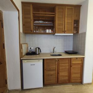 a kitchen with wooden cabinets and a white dishwasher at Eski Datca Evleri in Datca +65 photos