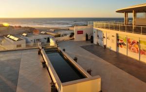 カザル・ダ・ラゴア・セッカにあるPraia Del Rey SeaView Dupplexの海辺のスイミングプール付きの建物