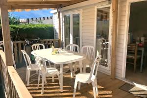 a white dining table and chairs on a deck at Mobil home 3 chambres, empl K079, les charmettes in Les Mathes +18 photos
