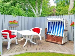 a deck with two chairs and a table and a table and chairs at Gaestehaus-Bruhn-5 in Alkersum +1 photo