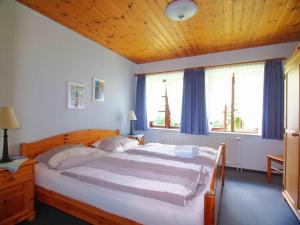 a bedroom with a large bed with a wooden ceiling at Gaestehaus-Bruhn-1 in Alkersum