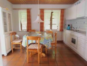 a kitchen with a table and chairs and a kitchen with a sink at Gaestehaus-Bruhn-1 in Alkersum