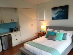 um quarto com uma cama com almofadas azuis e verdes em Drifted Away em Valla Beach