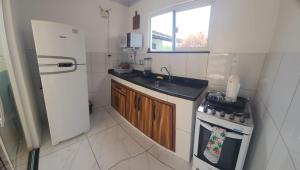 Una pequeña cocina con fregadero y estufa. en Casa 200 Arraial, en Arraial do Cabo 39 fotos más