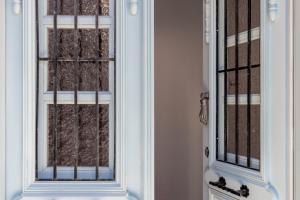 a door with a glass window with brown curtains at Chora Residence in Skopelos Town +26 photos