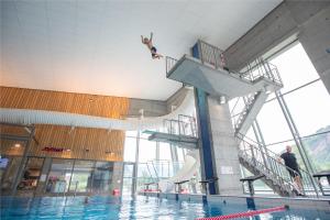a person jumping off of a swimming pool at Villa Fjellheim in Luster