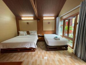 a bedroom with two beds and a window at Tam Coc Hello Homestay in Ninh Binh