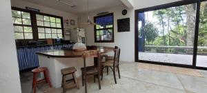 une cuisine avec un bar avec des chaises et une grande fenêtre dans l'établissement Casa em Maresias com vista pro mar, à São Sebastião