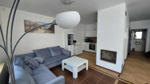 a living room with a blue couch and a table at Park Miedzywodzie in Międzywodzie